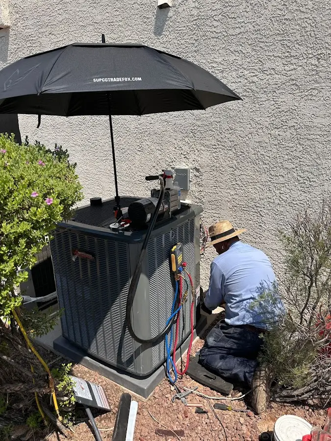 HVAC technician performing outdoor AC maintenance in Thompson